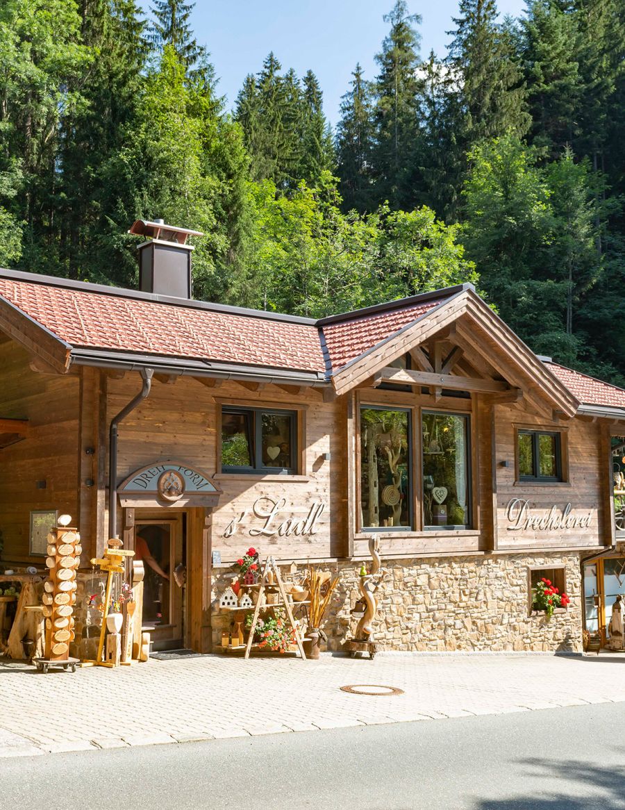 Außenansicht des Holzhauses mit ’s Ladl und Drechslerei in alpiner Umgebung
